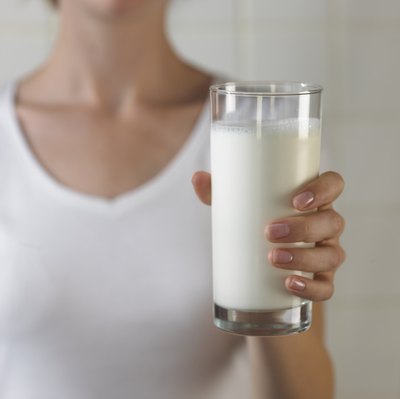 A woman holds a glass of milk.