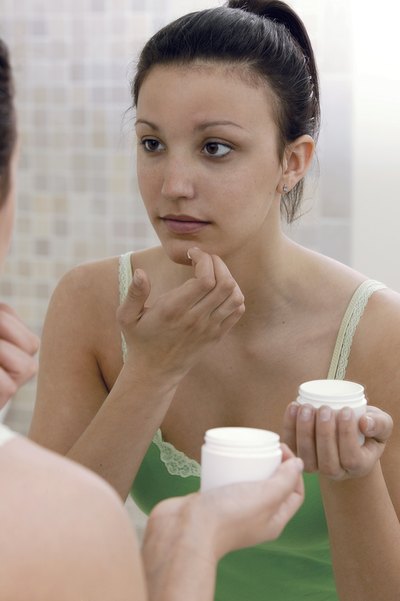 girl putting cream on her face