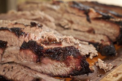 Cook beef brisket slowly over indirect heat to keep it tender.