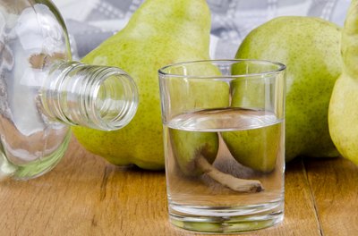 Fruit brandy in a glass with pears in the background.
