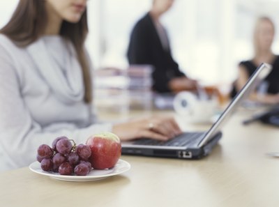 Woman sitting with fruit snack next to her on desk