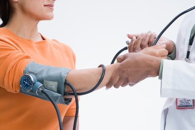 Doctor taking patient's blood pressure.
