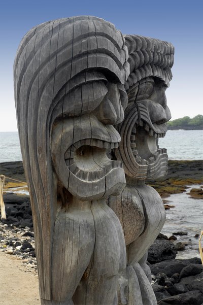 Two Tiki gods on an island beach.