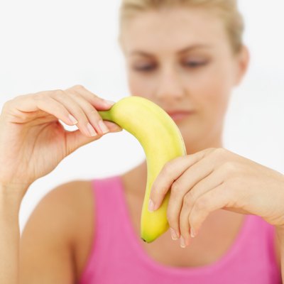 A woman is peeling a banana.
