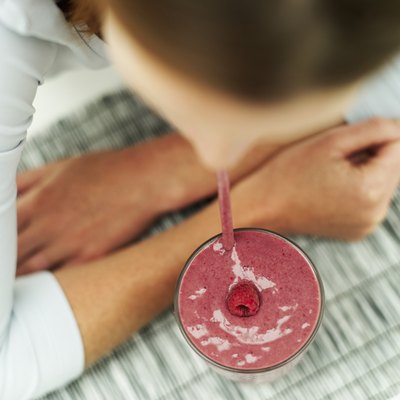 A woman drinks a fruit smoothie.