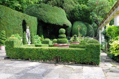 A manicured English garden in the back of a home.