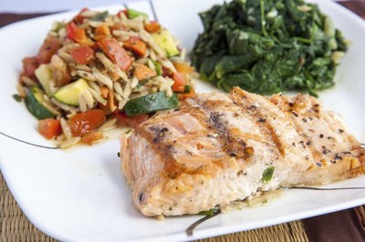 A plate with grilled salmon and vegetables.