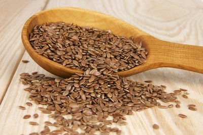 Flaxseed spilling out of a wooden spoon