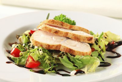 A plate with grilled chicken and vegetables.
