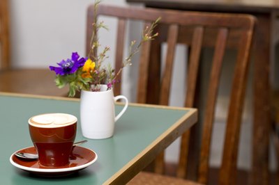 A mug of spring flowers on a coffeehouse table.