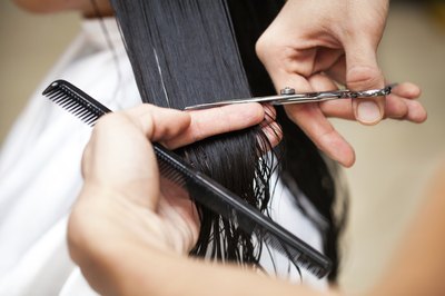stylist cutting woman's hair in salon