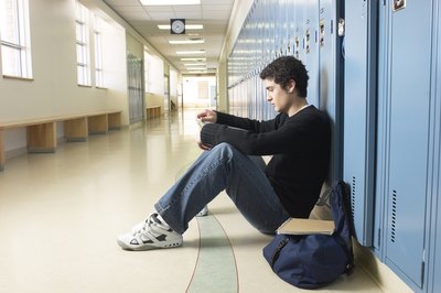 Teen sitting alone in hallway