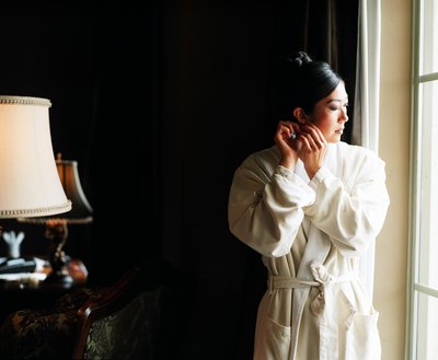 Woman taking earrings off in hotel room
