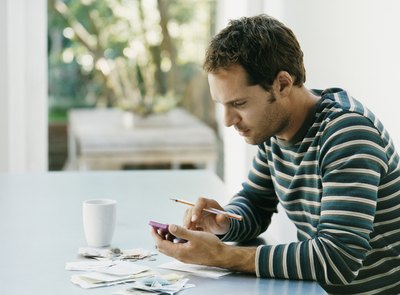 A man sitting with a calculator