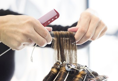 woman having curlers put into hair during perm