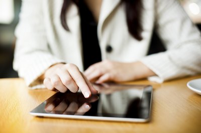 A close-up of a woman reading her tablet computer.