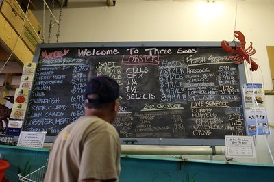 Customer reviewing prices at fish market in Maine