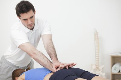 Therapist working on woman's lower back pain.