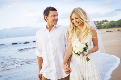 Newlywed couple walking on Caribbean beachfront
