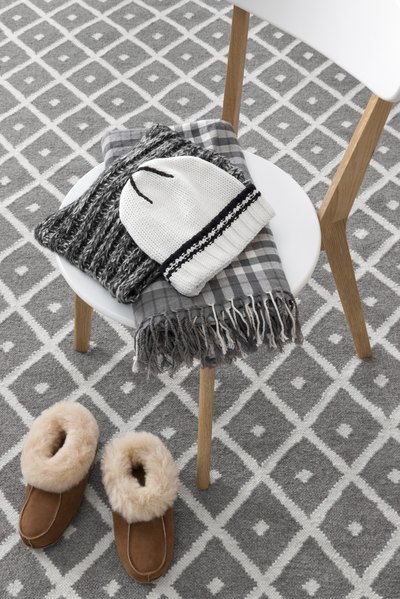 Close-up of a wool hat and scarf laying on a chair.