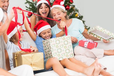 Family opening presents in front of a Christmas tree