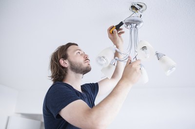 Man connecting light fixtures wires.