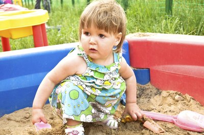 Little girl playing in sandbox