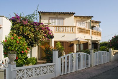 A Spanish style home with floral landscapeing in the front.