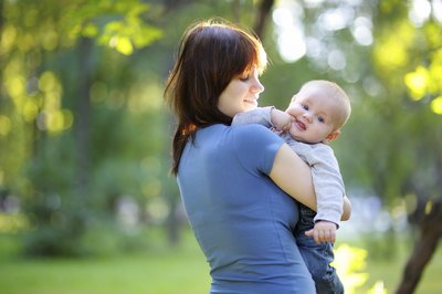 A woman taking an infant to the park
