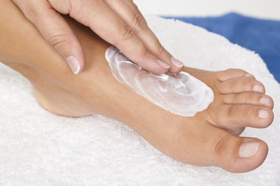 Woman putting topical lotion on her foot