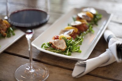 Seared fish and vegetables on a bed of fresh greens.
