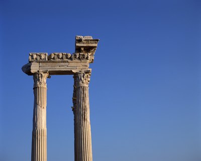 Ruins of Ionic columns surmounted by an architrave and a carved frieze piece.