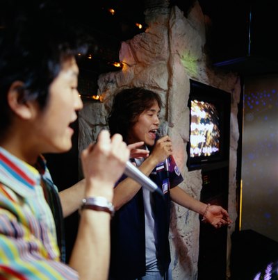 Two men singing at a karaoke bar