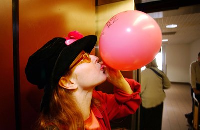 Woman blowing up pink balloon