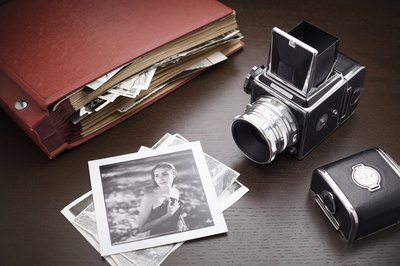 Vintage photos and a scrapbook on a desk.