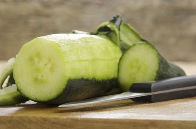 Peeled cucumber on cutting board.