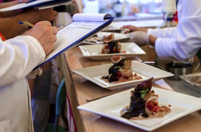 Judge evaluating dishes at a cooking contest.