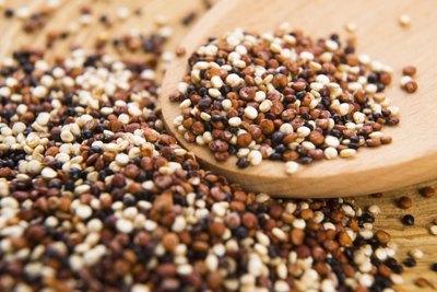 A mixture of tricolor quinoa grain on a spoon and table.