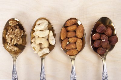 Spoons filled with different kinds of nuts.