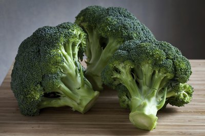 Pieces of fresh broccoli on cutting board.