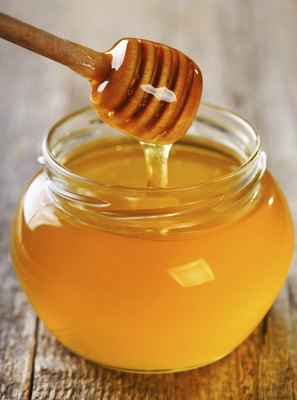 nitrub/iStock/Getty Images A bit of honey is a natural remedy to help your dog's cough.