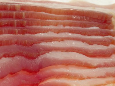 Medioimages/Photodisc/Photodisc/Getty Images Raw bacon or other pork meat can cause trichinosis.