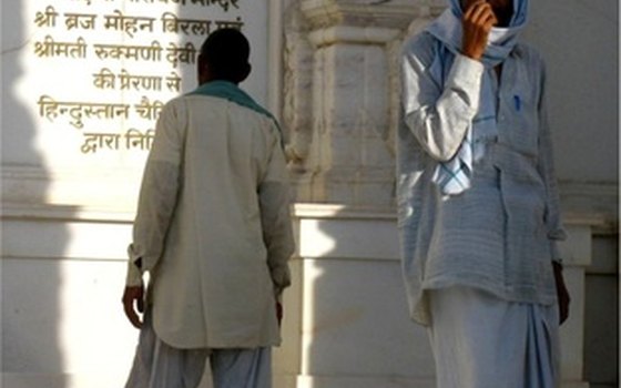 The man on the left is wearing shalwar kameez, and the man on the right is wearing a doti.