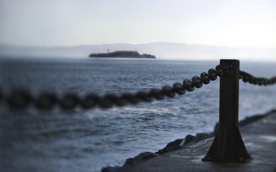 The forboding shape of Alcatraz protrudes darkly from the San Francisco Bay.