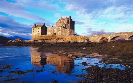 Visitors cross a small bridge to visit Scotland's mysterious Eileen Donan Castle.