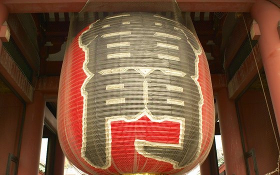 Enter a walkway to Sensoji Temple under the tall red gates and gigantic lantern.