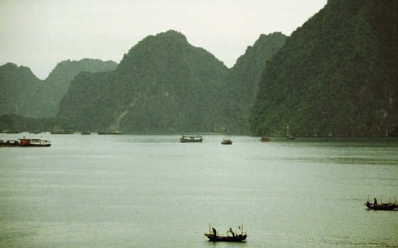Take a boat tour of Halong Bay to see the vegetation-covered karst formations.