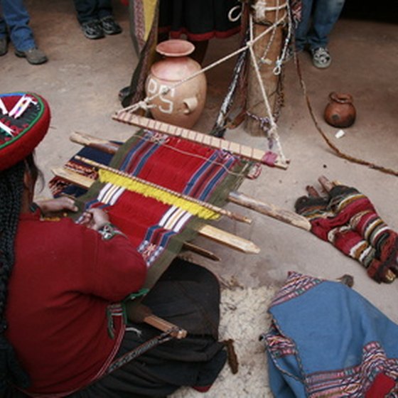 An indigenous woman weaving on a backstrap loom.