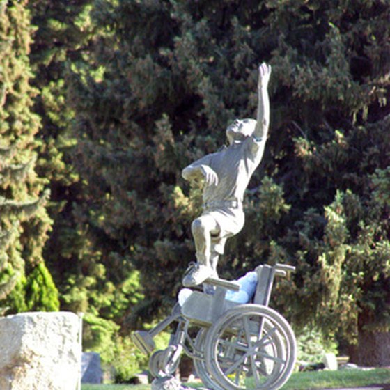 Statue of a child standing from a wheelchair.