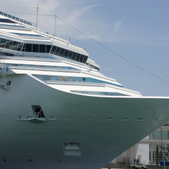 A cruise ship docked by the shore beckons travelers to come aboard.